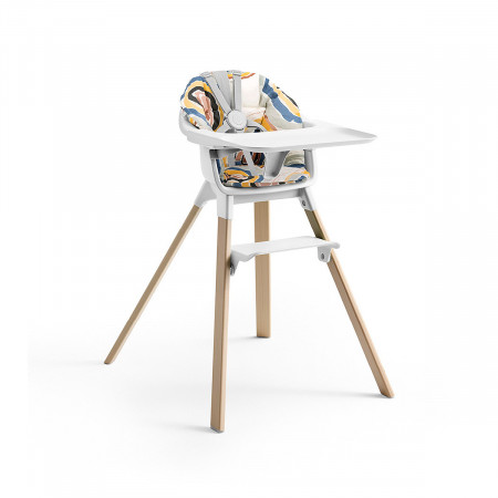 Cojín trona Clikk de Stokke, trona de color blanco y patas de madera.