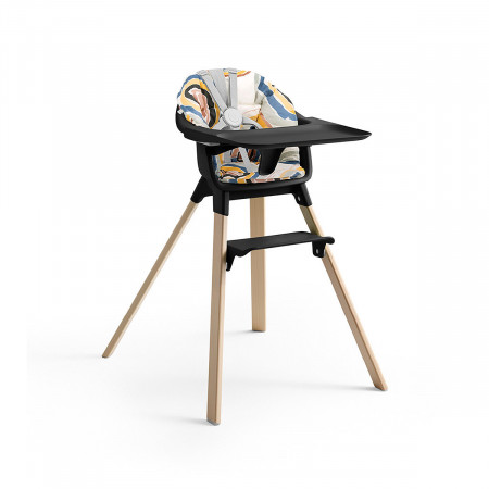 Cojín trona Clikk de Stokke, trona de color black y patas de madera.