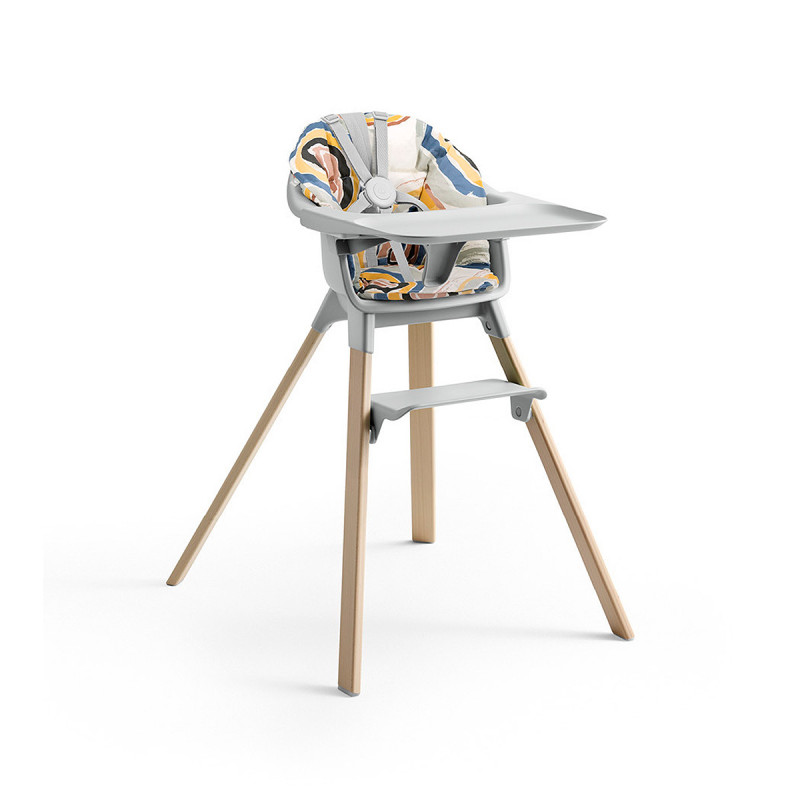 Cojín trona Clikk de Stokke, trona de color gris nube y patas de madera.