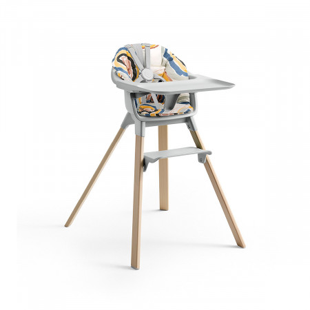 Cojín trona Clikk de Stokke, trona de color gris nube y patas de madera.